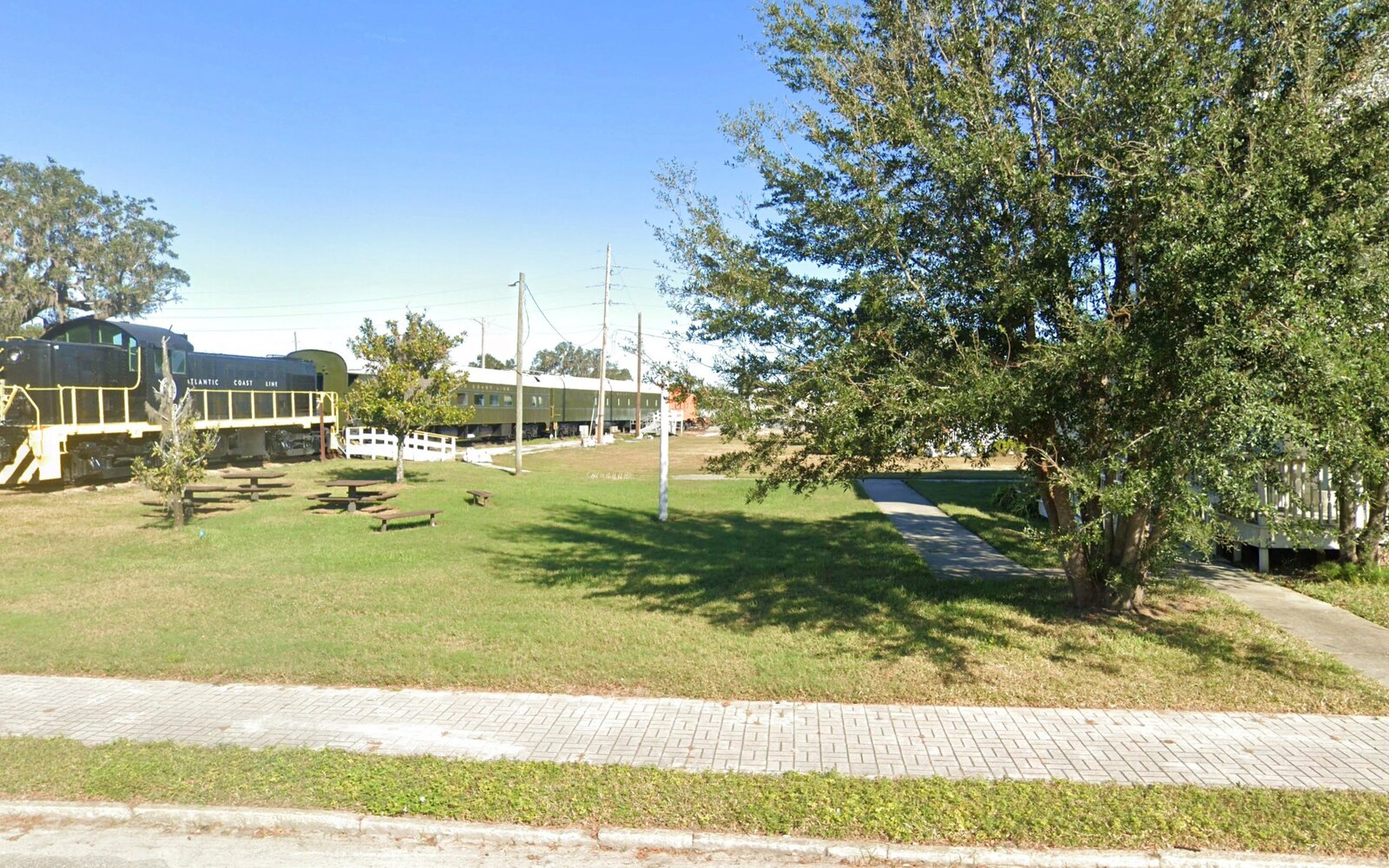 The historic Atlantic Coast Line locomotive and passenger cars on the downtown rail site — the heart of the proposed Heritage Train Park. BusinessFlare® site documentation.